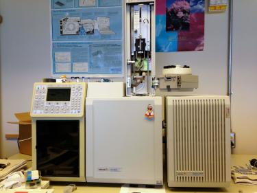 A cream colored boxy piece of scientific equipment on a desk in a lab